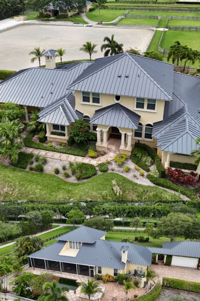 Aerial front and rear views of an estate with dark standing seam metal roofing